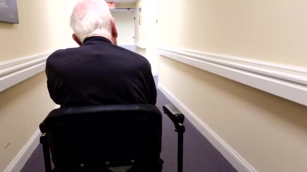 Ένας Ηλικιωμένος Οδηγεί Ένα Ηλεκτρικό Σκούτερ Μέσα Από Ένα Διάδρομο — Αρχείο Βίντεο