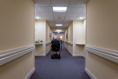 Solomons, Maryland, ABD 27 Temmuz 2023 Bir koridorda elektrikli scooterla huzurevinde son sınıf öğrencisi.