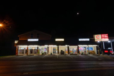 Broomes Adası, Maryland, ABD 27 Temmuz 2023 Geceleri bir köşedeki ucuz içki, market ve benzin deposu.