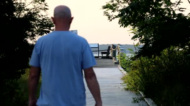 パインポイント メリーランド アメリカ合衆国 チェサピーク湾沿いのボードウォークを歩く男 — ストック動画