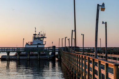 Solomons, Maryland, ABD Gün batımında Patuxent Nehri 'ndeki bir rıhtıma bir römorkör yanaştı..