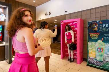 Lexington Park, Maryland, USA 3 Ağustos 2023 Bir sinemanın lobisine gelen izleyiciler Barbie pazarlama malzemeleriyle selfie çekiyorlar..