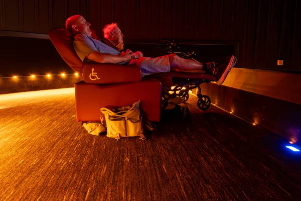 Lexington Park, Maryland USA  A man sits in a reclining movie theatre seat during the projection oif a movie.
