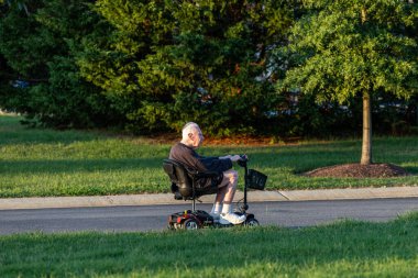 Solomons, Maryland, ABD Emekli bir adam elektrikli pille çalışan bir scooter kullanıyor..