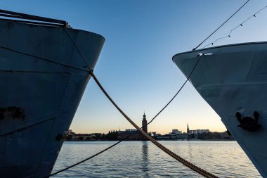 Stockholm, İsveç. Şafak vakti Belediye Binası 'nın manzarası Malaren Gölü' ndeki iki geminin demirleme hatları arasında görüldü..