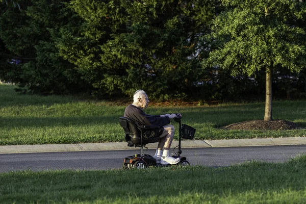 Solomons, Maryland, ABD Emekli bir adam elektrikli pille çalışan bir scooter kullanıyor..