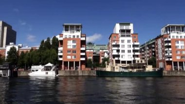 Stockholm, İsveç Sodermalm bölgesindeki konut binalarının teknesinden hareketli bir kanal görüntüsü..  