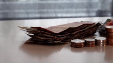 Masanın üzerinde para ve bozuk para tomarı.. 
