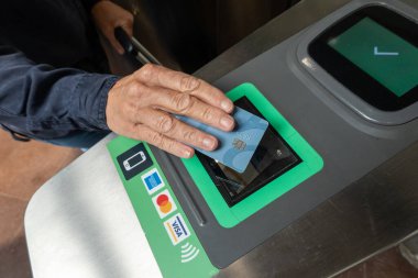 Stockholm, İsveç 21 Ağustos 2023 metro ücretini ödemek için metro turnikesinde kredi kartını kullanan bir kadın..