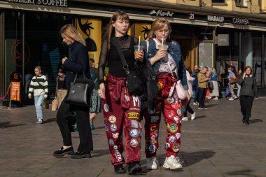 Helsinki, Finlandiya 22 Ağustos 2023 'te Stockmann alışveriş merkezinin yakınında okul sadakat bantları olan tipik öğrenci kıyafetleri içindeki öğrenciler kahve yudumluyorlar..