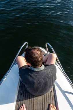 Stockholm, İsveç 'te yaz boyunca Malaren Gölü' nde küçük bir teknenin pruvasında genç bir adam oturuyor..