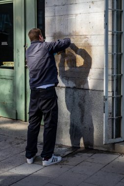 Stockholm, İsveç 29 Ağustos 2023. Bir adam kimyasallarla dolu bir binanın yüzeyinden grafiti temizliyor..