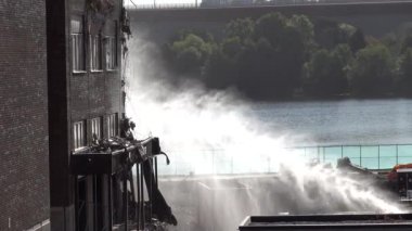 Stockholm, İsveç Marievik liman bölgesinde eski bir ofis binası yıkıldı ve toz bulutunu bastırmak için su püskürtüldü.. 