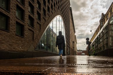 Helsinki, Finlandiya 'da yağmurlu bir günde Helsinki Üniversitesi Kütüphanesi' nin cephesinden bir kişi geçer..