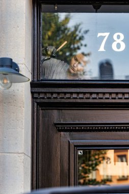 Stockholm, İsveç 8 Eylül 2023 Curgardsstaden tarihi bölgesindeki eski bir binanın girişini boyayan genç bir kadın..