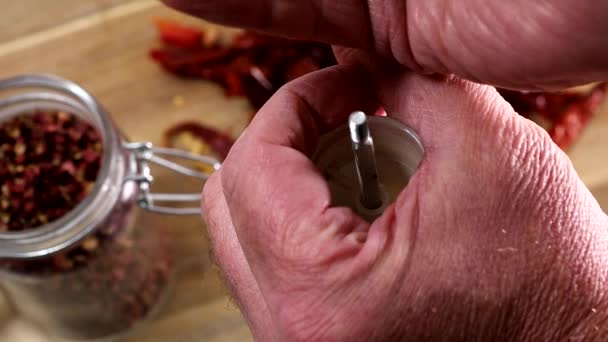 一只手在厨房的木板上用干胡椒填满胡椒磨坊 — 图库视频影像