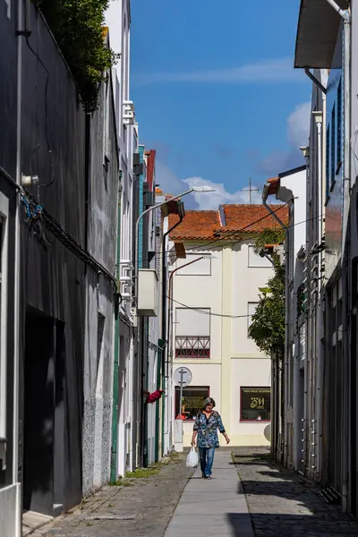 2023年9月20日 葡萄牙阿韦罗 一个提着购物袋的女人走在一条狭窄的街道上 — 图库照片