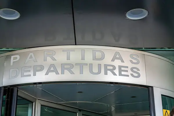 Porto, Portugal A departures sign in a revolving door in English and Portuguese  at the Francisco Sa Carneiro Airport.