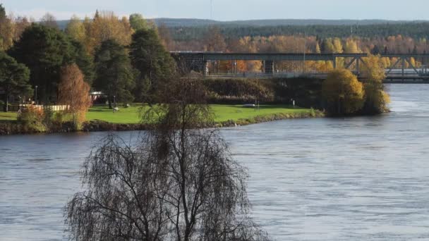 芬兰罗瓦涅米 Rovaniemi 芬兰最长的河流 凯米乔基河 Kemijoki River 堤岸和乌纳木斯克铁路桥的景观 — 图库视频影像
