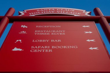 Rovaniemi, Finlandiya, 10 Ekim 2023 Red mağazası ve şehrin dışındaki Noel Baba Tatil Köyü turistik merkezindeki restoran tabelaları.