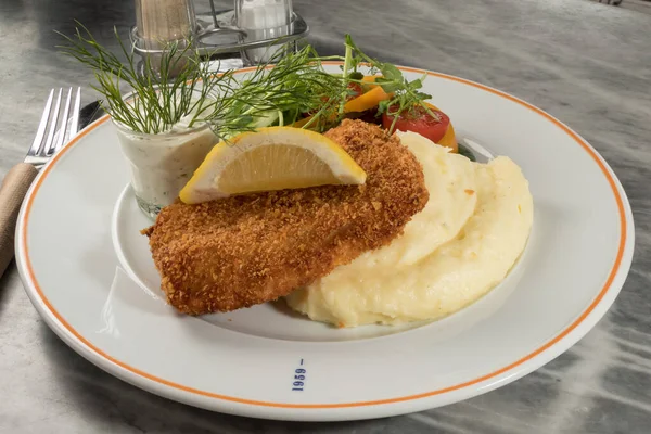 Patates püresi ile servis edilen morina filetosu. Ve bir dilim limon..