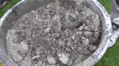 İnşaatçı elle karıştırıcı ile betonu karıştırır.. 