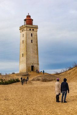 Rubjerg Knude Deniz Feneri, Danimarka 1 Kasım 2023 2018 'de kum tepesi ve su erozyonu nedeniyle taşınan ünlü Rubjerg Knude deniz fenerinin manzarası ve yürüyen insanlar..