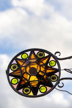 Odense, Danimarka 30 Ekim 2023 Kapı eşiğinde asılı duran bir vitray güneş sembolü.