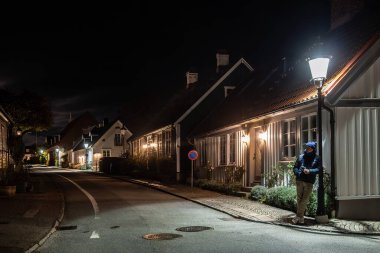 Piç, İsveç Bir adam gece eski kulübelerin arasında sokak lambasının altında duruyor Agardhsgatan 'da.