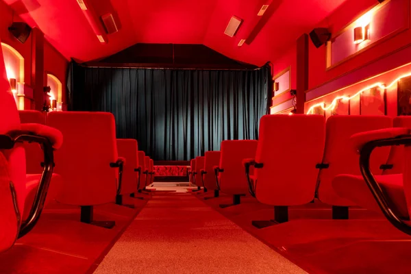 Piç, İsveç Koltukları ve perdesi olan eski bir sinema salonunun parlak kırmızı iç mekanı.