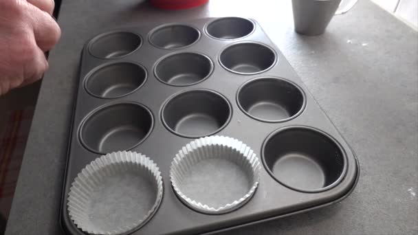 Cozinheiro Distribui Suportes Cupcake Papel Uma Bandeja Muffin Antes Assar — Vídeo de Stock
