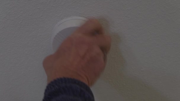 電池を点検するために天井からの火災警報を解除する男 — ストック動画