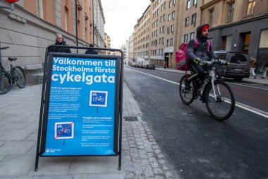 Stockholm, İsveç bisikletçileri Odenplan bölgesindeki Surbrunnsgatan 'da yeni açılan bisiklet yolunda ve İsveççe 