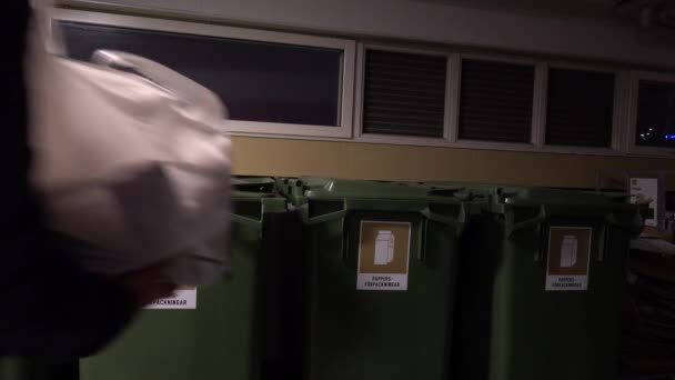 ストックホルム スウェーデン 男は段ボール包装のための指定された緑の受容器の段ボールの包装のゴミを投げ スウェーデンの印は紙の包装を言います — ストック動画