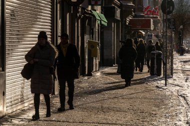 Stockholm, İsveç 24 Kasım 2023 güçlü kış ışığında Gotgatan 'da yürüyen siluetli yayalar..