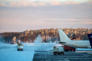 Stockholm, İsveç Arlanda Havaalanı 'ndaki karlı pistte bir uçak buzdan arındırıldı..