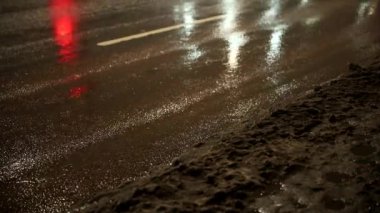 Stockholm, İsveç Karı, buz ve erimiş su yoğun bir yolda gece trafiğinde sıçradı.. 
