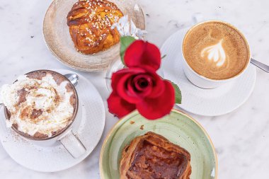 Stockholm, İsveç İsveç 'te bir İsveç fika' sı ya da kahve molası için güllü rahat bir kafe masası tarçınlı çörek ve çikolatalı sıcak çikolata..