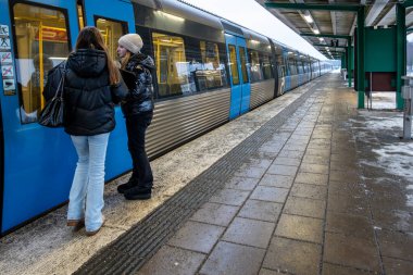 Stockholm, İsveç 13 Aralık 2023 İki liseli kız Bromma banliyösünde metroya ya ya da tünele girmek için bekliyorlar.