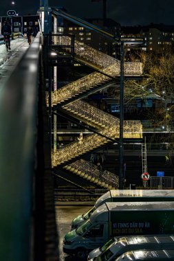 Stockholm, İsveç 20 Aralık 2023 'te gece vakti Liljeholmen morluklarında Noel süslemeleri yapan yayalar..
