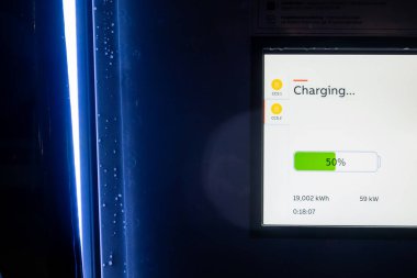 Varnamo, İsveç EV elektrikli araba şarj istasyonunun ekranı şarj seviyesini gösteriyor.