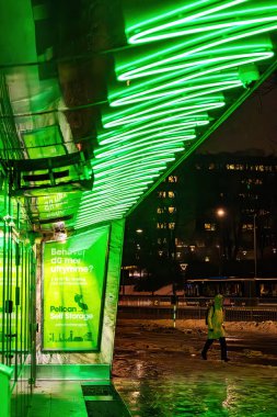 Stockholm, İsveç 29 Aralık 2023. Bir kadın sabahın erken saatlerinde eski bir yeşil film tabelasının önünden geçiyor..