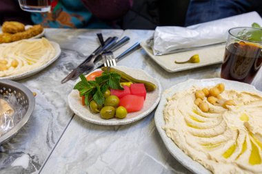 Stockholm, İsveç Ragsved bölgesinde popüler bir falafel restoranında humus, falafel ve sebzelerle dolu bir masa..
