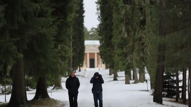 ストックホルム スウェーデンの父と息子 冬のユネスコ世界遺産ウッドランド墓地を歩く — ストック動画