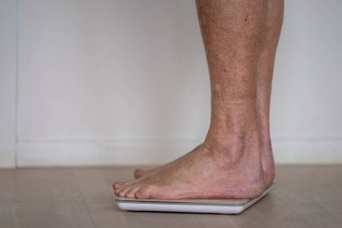 Kış ayağında kuru bir adam banyo terazisinde tartılır..