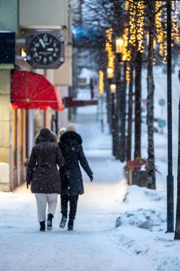 Stockholm, İsveç 3 Ocak 2024 Sundbyberg banliyösündeki Sturegatan 'da kar üzerinde yürüyen yayalar.