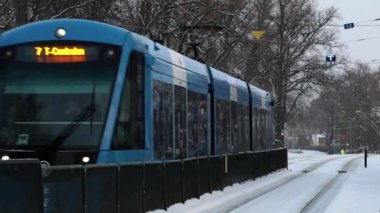 Stockholm, İsveç Karda Djurgarden adasında bir tramvay yaklaşıyor..