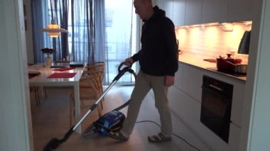 Stockholm, İsveç Bir adam bir ev mutfağını süpürüyor 