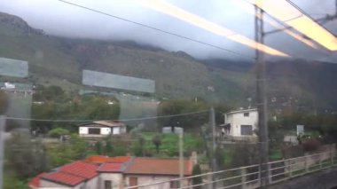 Palermo, Sicilya, İtalya Hareket halindeki bir trende oturan bir kadın pencere kenarından manzaranın keyfini çıkarıyor.  