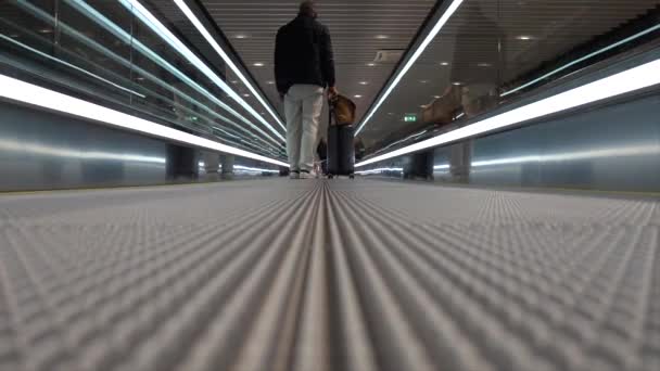 瑞典斯德哥尔摩 一名男子在亚兰达机场的一条滚动人行道上 提着行李 — 图库视频影像